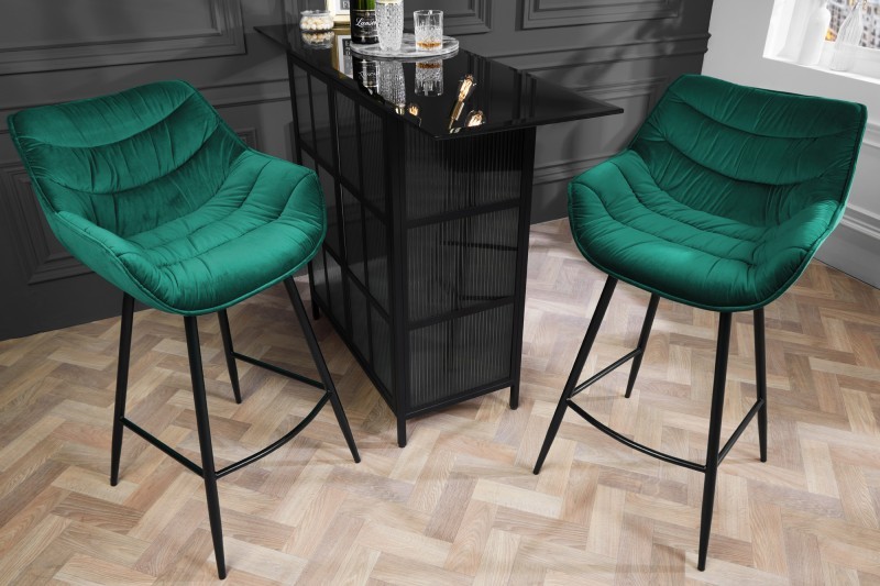 Estila Dizajnová moderná barová stolička Kotor so smaragdovozeleným zamatovým čalúnením a čiernymi nohami z kovu 105cm