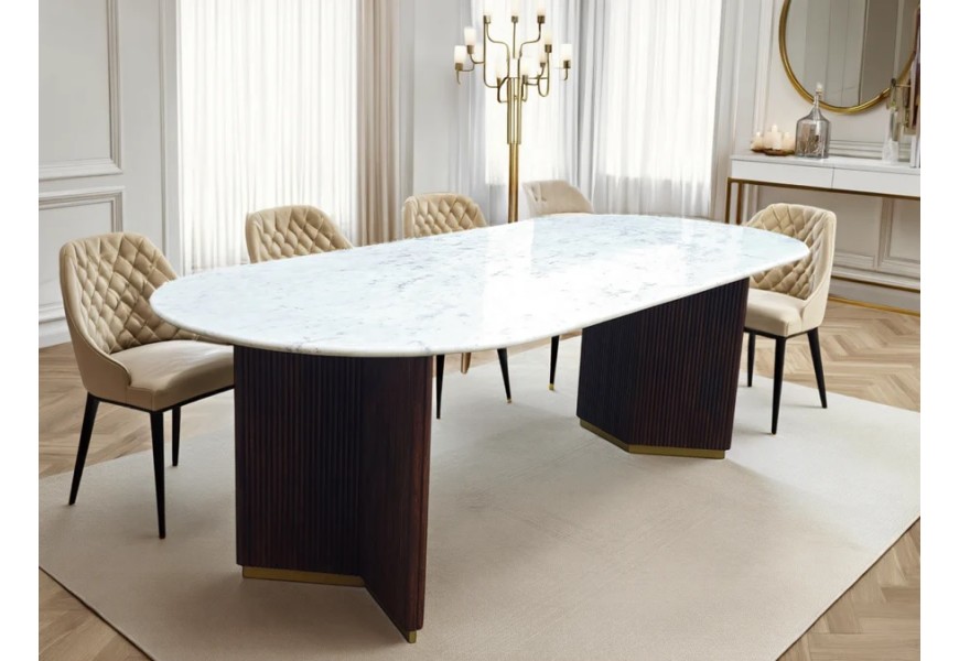 Luxusný mramorový jedálenský stôl Gatsby s bielou oválnou vrchnou doskou so sivým žilkovaním a dvomi masívnymi mangovými nohami s vertikálnym drážkovaným reliéfom v tmavej hnedej farbe so zlatým detailom s pôdorysom v tvare V