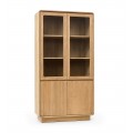 Luxusná moderná masívna knižnica Riga s vrchnými sklenenými dvierkami a spodnými plnými dvierkami z teakového dreva v naturálnej svetlej hnedej farbe s policami a obdĺžnikovou podstavou so zaoblenými rohmi a vertikálnym lineárnym reliéfom
