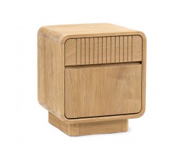 Luxusný moderný nočný stolík Riga s úložným priestorom s jednodverovou skrinkou a zásuvkou zdobenou vertikálnym lineárnym reliéfom so zaoblenými rohmi  a úzkou plnou podstavou z masívneho teakového dreva v svetlej hnedej farbe s naturálnou kresbou letokruhov