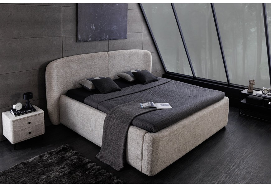 Štýlová dizajnová čalúnená posteľ v art deco štýle s buklé poťahom v sivej farbe so širokým oblým čelom a výklopným roštom s priestranným úložným priestorom