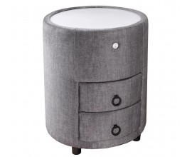 Dizajnový čalúnený okrúhly nočný stolík Aluro so sivým poťahom zo zamatu s dvomi zásuvkami a nízkymi čiernymi nožičkami s bielou vrchnou doskou s LED podsvietením