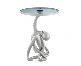 Glamour pr&iacute;ručn&yacute; stol&iacute;k Tierra Glam v okr&uacute;hlom tvare so sklenenou priehľadnou doskou v sivom odtieni s led svietidlom s kovovou striebornou nohou v podobe chobotnice
