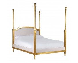 Luxusn&aacute; klasick&aacute; manželsk&aacute; posteľ Dimitria z mas&iacute;vneho mahag&oacute;nov&eacute;ho dreva v zlatej farbe s vyrez&aacute;van&iacute;m s čal&uacute;nen&yacute;m čelom a r&aacute;mom potiahnut&yacute; ľanom v b&eacute;žovej farbe