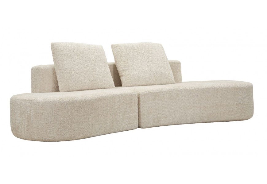 Dizajnová moderná čalúnená štvormiestna sedačka Lilos v atypickom oblom tvare s dvomi štvorcovými vankúšmi v krémovej bielej farbe so semišovým poťahom bez bočných opierok