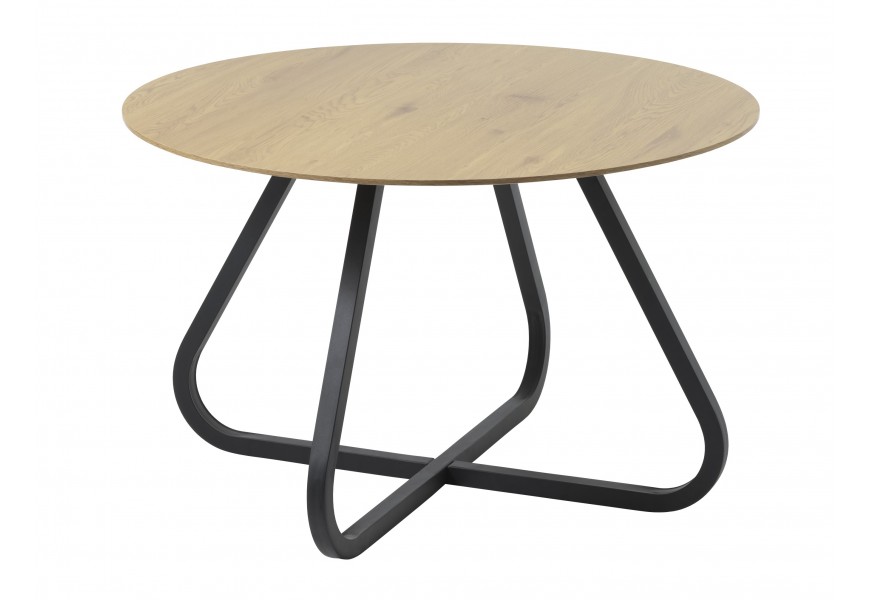 Moderný industriálny jedálenský stôl Holstebro s okrúhlou vrchnou doskou z melamínovej dyhy v prírodnom svetlom hnedom dubovom prevedení a podstavou z kovu v čiernej farbe so štyrmi zakrivenými nohami a spojnicou v tvare kríža