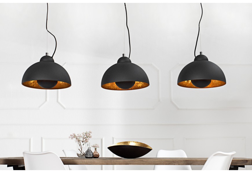Závesné trojité svietidlo s polkruhovými kovovými tienidlami v čiernej farbe so zlatým vnútrom zavesené na lankách v industriálnom štýle vhodné nad jedálenský alebo barový stôl