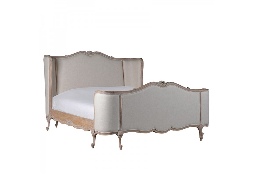 Provensálska manželská king size posteľ Kingly s vyrezávanou konštrukciou z mahagónového dreva a čalúnenými čelami v béžovej farbe