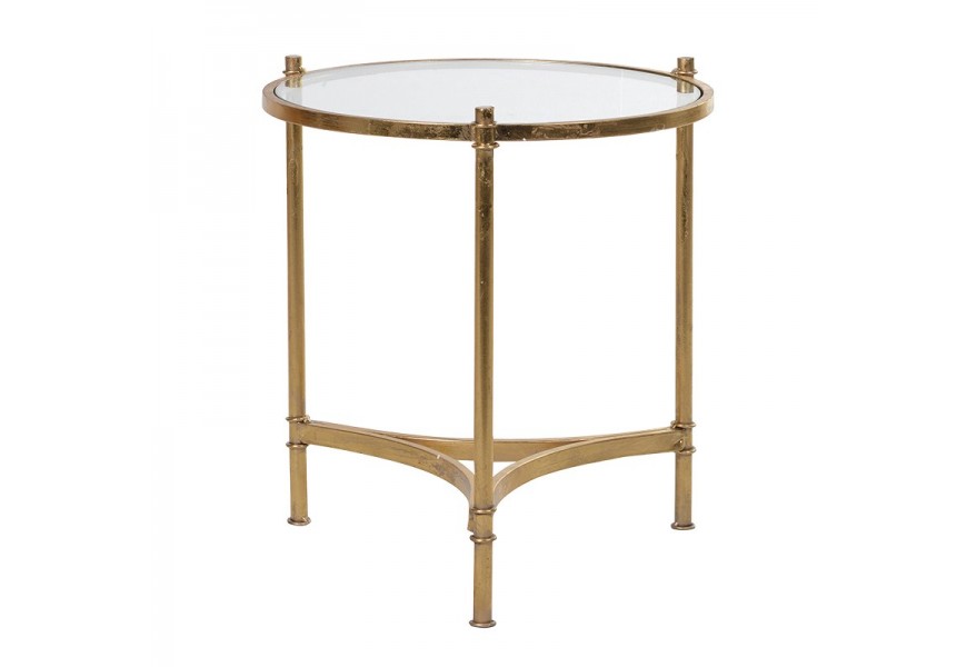 Okrúhly príručný stolík Francine v glamour štýle s transparentnou sklenenou vrchnou doskou a tromi nožičkami prepojenými trojuholníkovou podstavou z kovu v zlatej farbe