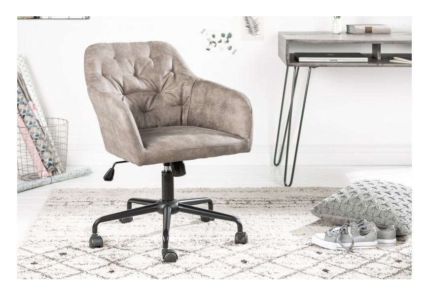 Dizajnová pracovná stolička s operadlom, čalúnená sivou zamatovou látkou s jemným vintage efektom a prešívaným vzorom, doplnená čiernou kovovou podstavou s kolieskami a nastaviteľnou výškou, vhodná do moderných alebo industriálnych interiérov