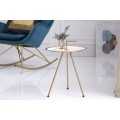 Dizajnový príručný stolík bielej farby s konštrukciou v zlatej farbe.