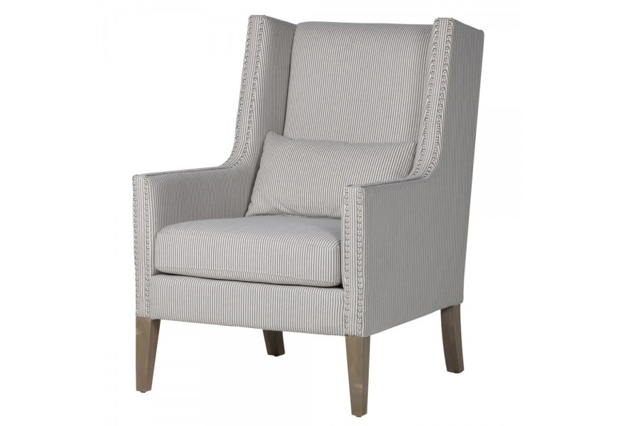 Štýlové čalúnené kreslo Fiesta s bledým poťahom a sivomodrými pásikmi, doplnený o strieborné sponky.