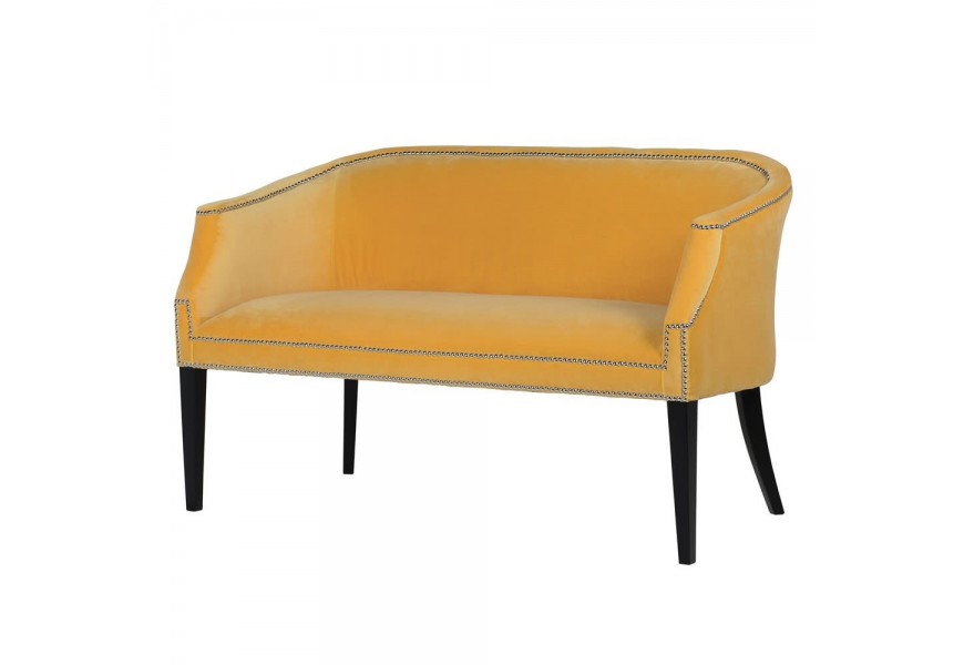 Luxusná art-deco lavica Aldea v horčicovožltej farbe s dizajnovými kovovými cvokmi na okrajoch a s nohami z masívneho dreva