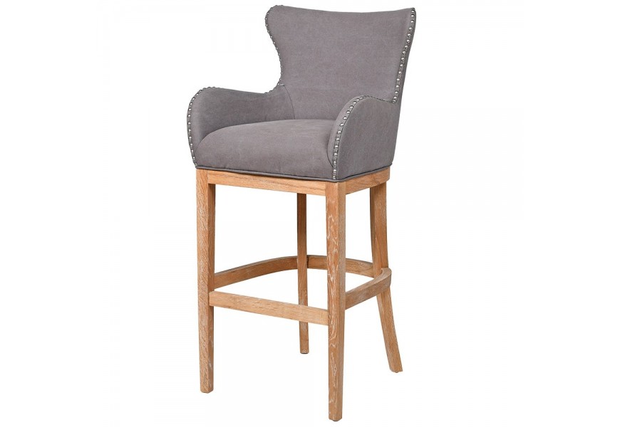 Štýlová retro barová stolička Oakly s poťahom v sivej farbe a s kovovým vybíjaním a aplikáciou a s masívnymi nohami