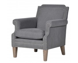Štýlové kreslo Alexandria so sivým čalúnením, s kovovými cvokmi a s nožičkami z masívneho jaseňového dreva