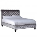 Nadčasová posteľ Alcala II s Chesterfield prešívaním šedého zamatovom poťahu čalúnenia a s čiernymi nohami z dreva.
