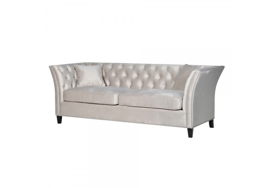 Chesterfield sedačka s prešívaním na lesklom zamatovom požahu v odtieňoch bielej doplnená čiernymi masívnymi nohami