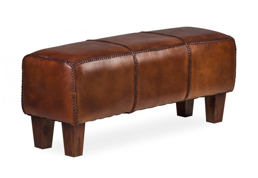 Koloniálna kožená hnedá lavica Trenza s mohutnou obdĺžnikovou sedacou časťou s poťahom z pravej kože v koňakovom hnedom odtieni s hranatými drevenými nožičkami z teakového dreva v naturálnej hnedej farbe s pirodzenou kresbou letokruhov