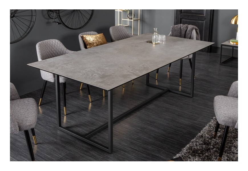 Dizajnový industriálny jedálenský stôl Collabor s povrchovou doskou sivej farbe s efektom betónu a čiernymi kovovými nohami