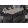 Dizajnový industriálny jedálenský stôl Collabor s povrchovou doskou sivej farbe s efektom betónu a čiernymi kovovými nohami