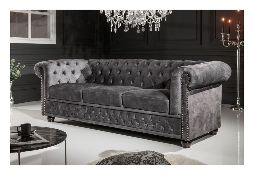 Dizajnová chesterfield sedačka Lobella v sivej farbe so zamatovým čalúnením a kovovými cvokmi