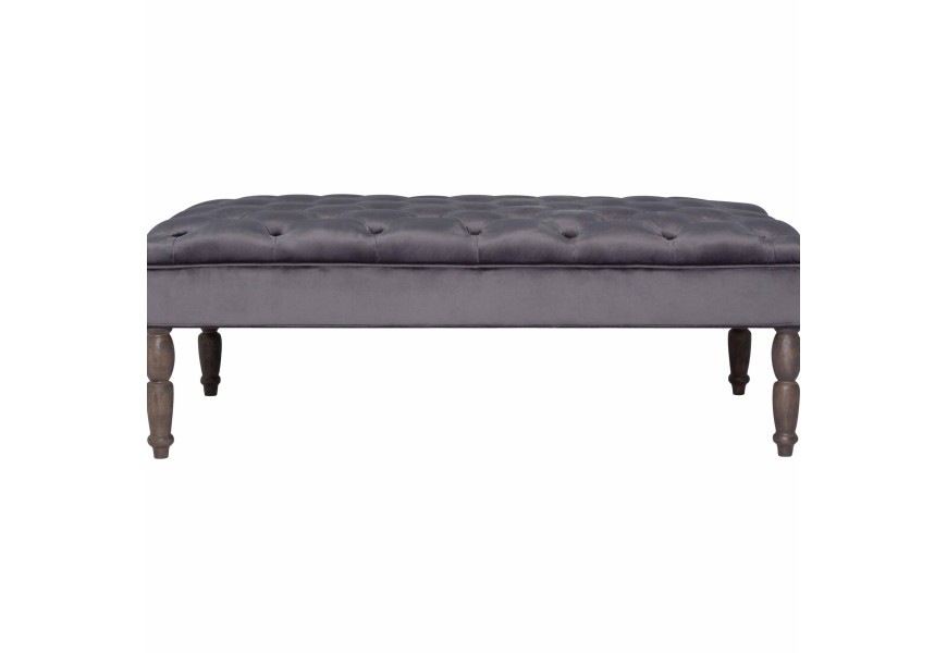 Dizajnový taburet Galahad v art-deco štýle s tmavo sivým zamatovým poťahom s masívnymi rustikálnymi nožičkami