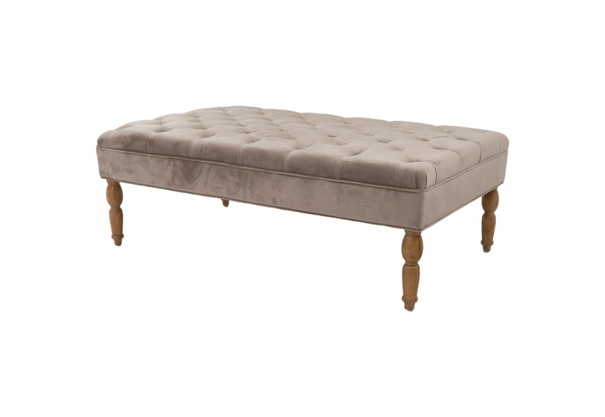 Elegantná prešívaná taburetka Chelsea so zamatovým čalúnením béžovej farby a s vyrezávanými drevenými nožičkami