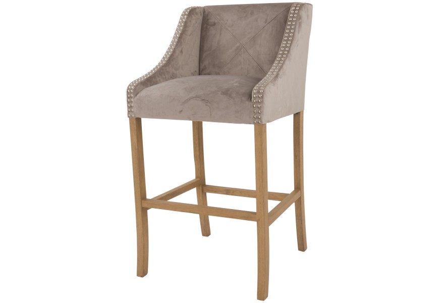 Elegantná čalúnená barová stolička Chelsea s poťahom zo zamtu béžovej farby a s kovovým strieborným zdobením