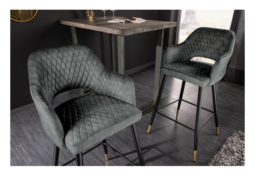 Moderná barová zamatová stolička Fribourg v krásnej sivozelenej tmavej farbe na kovových čiernych nožičkách s lesklou zlatou špičkou nožičiek