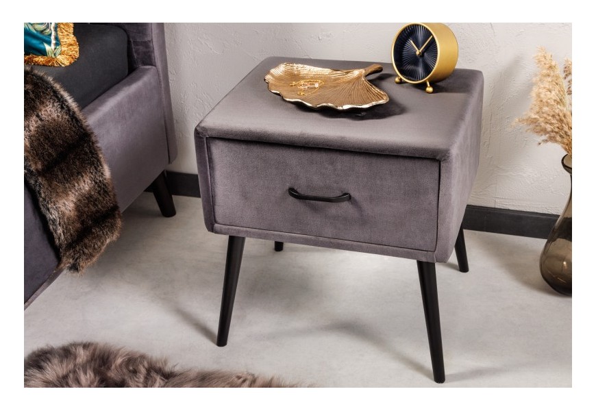Dizajnový nočný stolík Alva so sivým čalúnením so zamatu a šikmými kovovými nožičkami v čiernej farbe