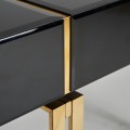 Moderný čierny konzolový stolík Bynum v sklenenom vyhotovení so zásuvkou a kovovou podstavou v zlatej farbe 120cm