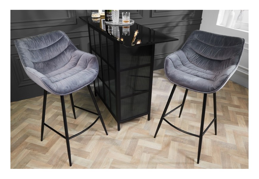 Dizajnová industriálna barová stolička Kotor v sivom prevedení so zamatovým čalúnením a čiernymi nohami