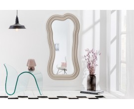 Asymetrické dizajnové zrkadlo Swan s polyuretánovým rámom v svetlej béžovej farbe s kaskádovým efektom 100cm