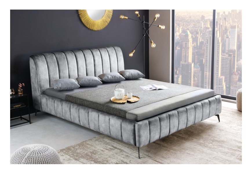 Moderná manželská čalúnená posteľ Orlando v sivom zamatovom prevedení na čiernych nožičkách z kovu s mohutným čelom a vertikálnym prešívaním