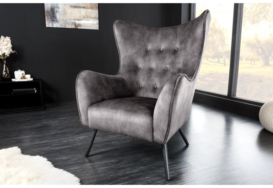 Retro kreslo ušiak Bolte so sivým zamatovým poťahom a čiernymi kovovými nožičkami.