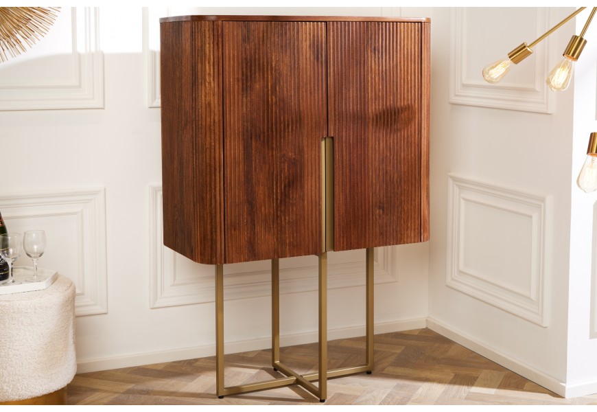 Luxusná art-deco barová skrinka Gatsby s oblými hranami a reliéfnou výzdobou z mangového masívneho dreva v hnedej medovej farbe s prekríženými zlatými nožičkami 125 cm