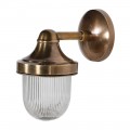 Dizajnová nástenná lampa Cotelo s možnosťou umiestnenia aj do exteriéru s držiakom z mosadze v starožitnej zlatej farbe a rebrovaným tienidlom so skla