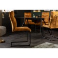 Moderná jedálenská stolička Vitto so zamatovým čalúnením v horčicovej žltej farbe a s čiernou kovovou úchytkou 45 cm