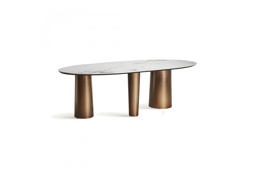 Luxusný glamour jedálenský stôl Marinna s oválnou vrchnou doskou z bieleho mramoru a tromi hrubými atypickými kovovými nohami v zlatej farbe