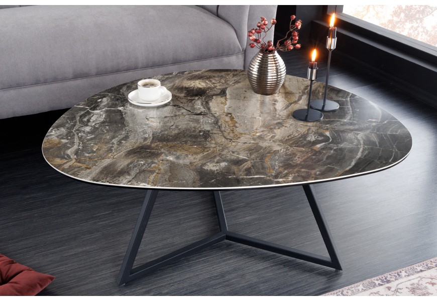 Moderný konferenčný stolík s trojuholníkovou vrchnou doskou so zaoblenými rohmi a hranami s dizajnom čierneho mramoru s hnedou a sivou kresbou v art deco štýle s tromi čiernymi kovovými nožičkami prepojenými podstavou