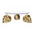 Dizajnový okrúhly konferenčný stolík Hamlet s tromi nožičkami v tvare lebiek v zlatej farbe a sklenenou vrchnou doskou 90 cm