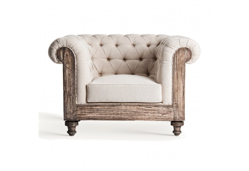 Luxusné vidiecke kreslo Gretchen vo vintage štýle s masívnou drevenou konštrukciou v svetlej hnedej farbe a béžovým prešívaným čalúnením v štýle chesterfield