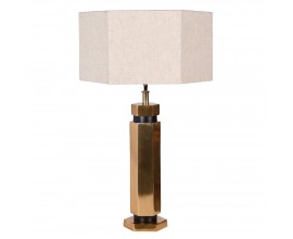 Dizajnová art deco stolná lampa Anasa s kovovou podstavou v lesklej zlatej farbe šesťuholníkového tvaru a textilným ľanovým tienidlom v svetlej béžovej farbe v tvare šesťuholníka