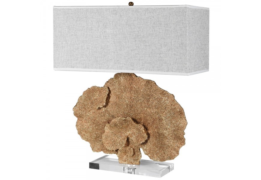 Dizajnová moderná stolová lampa Rebeca s dekoratívnym prvkom v zlatej farbe v tvare koralu a štvorcovou priesvitnou podstavou a sivým textilným obdĺžnikovým tienidlom tienidlom