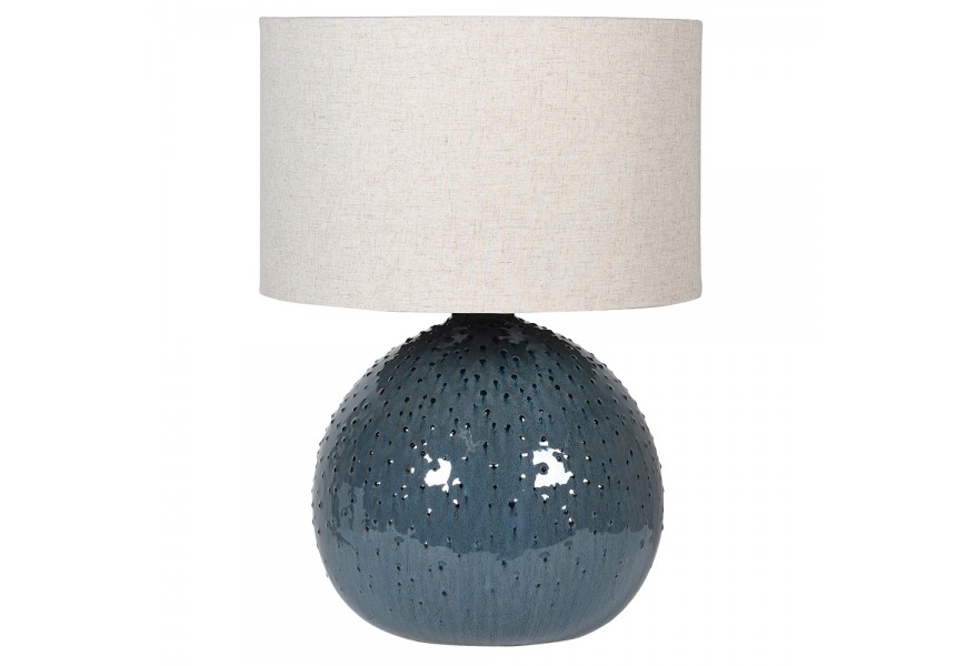 Moderná dizajnová keramická stolná lampa s valcovitým tienidlom z ľanovej textílie v oblačnej sivej farbe a guľatou modrou podstavou s asymetrickým reliéfnym bodovým zdobením
