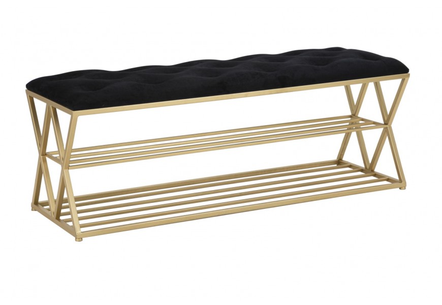 Dizajnová glamour čalúnená lavica Araccia s poťahom zo zamatu v čiernej farbe a kovovou konštrukciou v zlatej farbe s dvomi policami na topánky a geometrickým ozdobným prvkom na bočných stranách