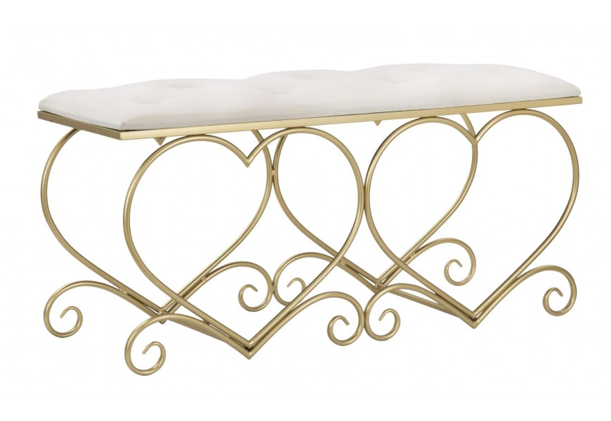 Dizajnová zámocká obdĺžniková lavica Amorattia s čalúneným sedadlom s prešívaním s okrúhlymi gombíkmi a poťahom zo zamatu v svetlej béžovej farbe a konštrukciou z kovu v zlatej farbe v tvare srdcových ornamentov