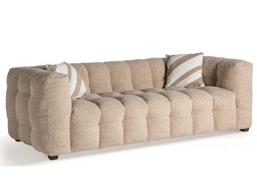 Luxusná glamour trojmiestna sedačka Mila v béžovej farbe s huňatým prešívaným poťahom a malými nožičkami v hranatom tvare v hnedej farbe s vankúšmi