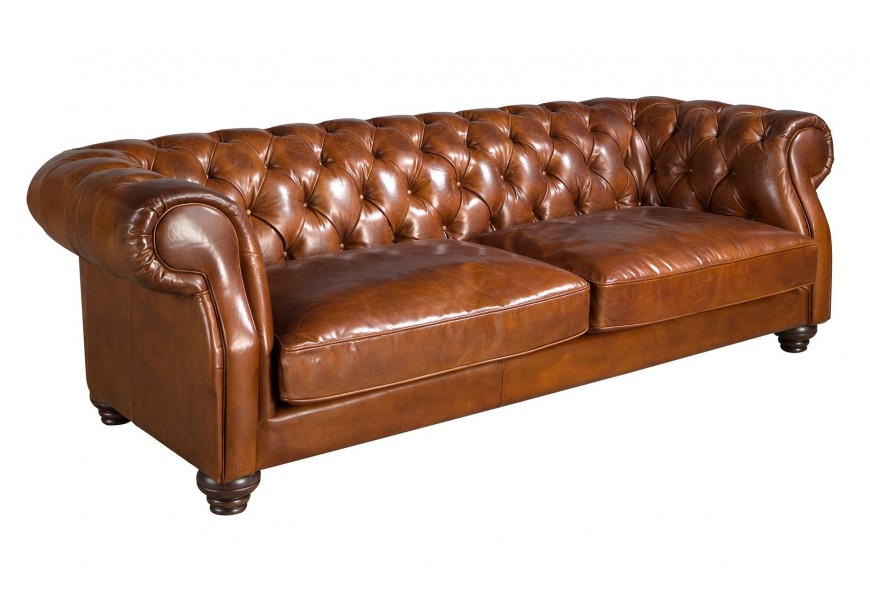 Luxusná klasická kožená trojsedačka Hastings s poťahom z pravej kože v koňakovej hnedej farbe s prešívaním s okrúhlymi gombíkmi a zahnutými opierkami s drevenými vyrezávanými nožičkami v mahagónovej hnedej farbe