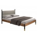 Luxusná moderná manželská posteľ Forma Moderna s čalúneným čelom so sivým prešívaným poťahom z eko kože s dreveným rámom v orechovej hnedej farbe a štíhlymi čiernymi nožičkami so zlatým kovovým akcentom